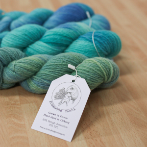 Three skeins of variegated yarn in shades of green, blue and turquoise