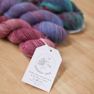 Three skeins of variegated yarn, in shades of pink, purple and turquoise