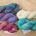 Five skeins of variegated yarn, in shades of pink, purple and turquoise, and natural cream