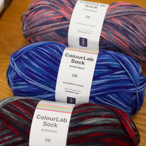 Three balls of DK sock yarn, in variegated colour-ways