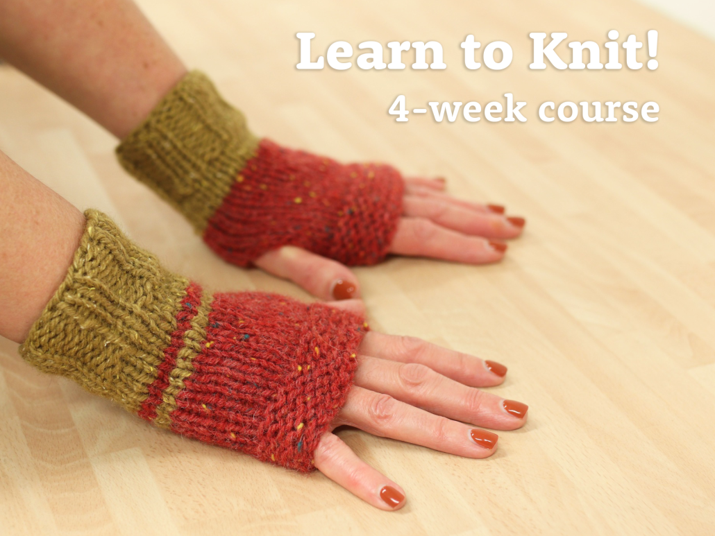 hands modelling hand-knitting fingerless mittens in 2 colours
